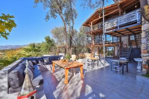 patio z niebieską kanapą i drewnianym stołem w obiekcie Kale Lodge - Adult Only + 15 w Kaş