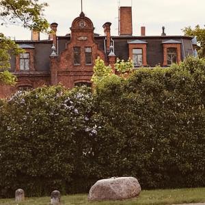 an old brick building with a clock tower on it at Raben Steinfeld Forststrasse Am Residence-Park in Raben Steinfeld