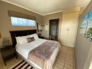 - une chambre avec un grand lit et une fenêtre dans l'établissement Beachfront Cabanas, à Amanzimtoti
