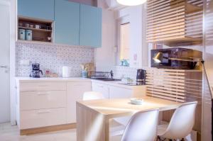 - une cuisine avec une table en bois et des placards blancs dans l'établissement Apartment Cubo Maksimir 1, à Zagreb