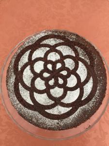 a chocolate cake on a glass plate on a table at B&B Magna Graecia in Scalea