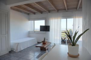 a white room with a bed and a table at Apartamentos Vista Vedrá in La Savina