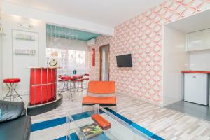 uma sala de estar com cadeiras vermelhas e uma mesa de vidro em Far Home Gran Vía em Madri