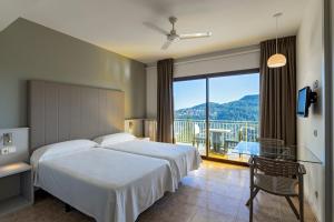 a hotel room with a bed and a large window at Can Fisa Hotel & Apartments in Corbera de Llobregat