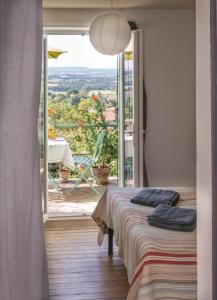 a room with two beds and a balcony with a view at 39 Tour de Ville in Monflanquin