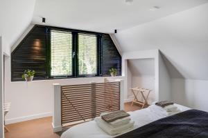 ein Schlafzimmer mit einem Bett und einem großen Fenster in der Unterkunft The Slow in Zuidoostbeemster