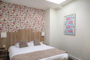 a bedroom with a large bed with a floral wall at Logis Hôtel Restaurant Lanex Amboise in Amboise