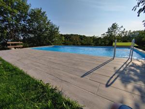 una piscina con un paseo marítimo de madera junto a en Il carpino bianco, en Puegnago sul Garda