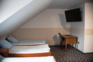 um quarto com 2 camas, uma secretária e uma televisão em Stacja Jura em Kroczyce