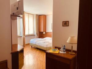 - une chambre avec un lit et un bureau avec une lampe dans l'établissement Hotel Saini, à Stresa