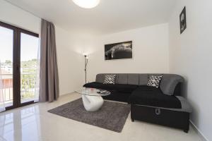 a living room with a couch and a glass table at Apartman TESSA in Vela Luka