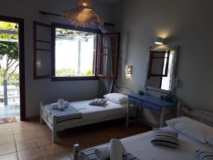 a bedroom with two beds and a mirror and a window at Ammos papanero in Agios Ioannis Pelio