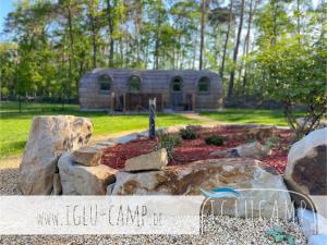 um jardim no quintal com uma casa de pedra ao fundo em Iglu Camp Heidewald em Sassenberg