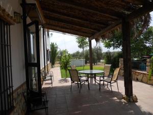 un patio con mesa y sillas. en La Aragonesa, en Marmolejo