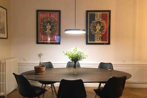 een eettafel met stoelen en posters aan de muur bij 5 min place Stanislas. Appartement de caractère in Nancy