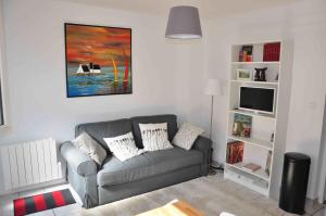 ein Wohnzimmer mit Couch und Fernseher in der Unterkunft Appartement cosy refait à neuf au coeur de Saint Nazaire à 300m du front de mer in Saint-Nazaire