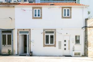 Weißes Haus mit weißen Türen und Fenstern in der Unterkunft Design Boavista Music Apartments in Porto