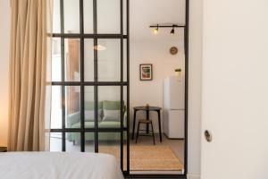 ein Schlafzimmer mit einem Bett und ein Zimmer mit einem Stuhl in der Unterkunft Design Boavista Music Apartments in Porto