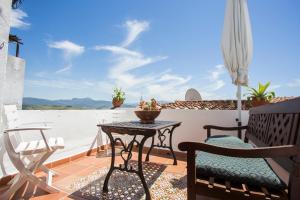 een patio met een tafel en stoelen op een balkon bij La Casita De Ana in Jimena de la Frontera