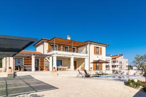 a large house with a swimming pool in front of it at Villa Evelyn in Medulin