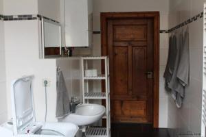ein Bad mit einem Waschbecken, einem WC und einer Tür in der Unterkunft Ferienwohnung "OTTO" in Erfurt + 9 Fotos