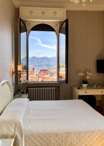 a bedroom with a bed and a large window at Hotel Du Parc in Stresa