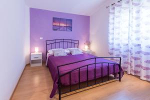 een slaapkamer met een paars bed en 2 nachtkastjes bij Villa Lavanda in Galižana +18 foto's