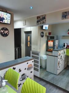 a small kitchen with green chairs and a counter at Hotel Kennedy in Milan