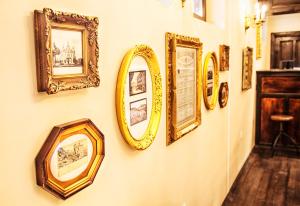 eine Wand mit vielen gerahmten Bildern an einer Wand in der Unterkunft Hotel Evmolpia in Plowdiw + 80 Fotos