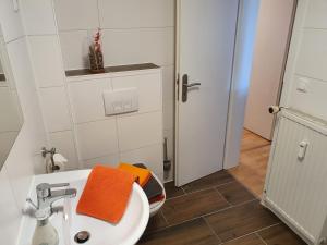 Un baño con un lavabo con una toalla naranja. en Nikolaikirch-Hof, en Wismar 33 fotos más