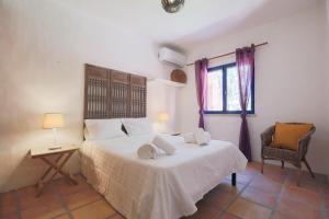 ein Schlafzimmer mit einem Bett und einem Stuhl und einem Fenster in der Unterkunft Villa Bambu in Charneca + 47 Fotos