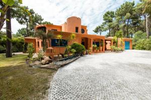 ein orangefarbenes Haus mit Auffahrt in der Unterkunft Villa Bambu in Charneca