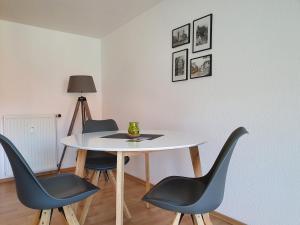Una mesa y cuatro sillas en una habitación en Nikolaikirch-Hof, en Wismar
