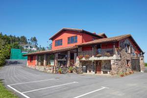 a building with a parking lot in front of it at Hotel Tejera del Nalon in Soto del Barco