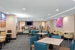 un ristorante con tavoli, sedie e un pianoforte di La Quinta by Wyndham Denver Aurora Medical ad Aurora