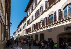 a group of people walking down a street next to buildings at Palazzo Alfani - Residenza d'Epoca in Florence