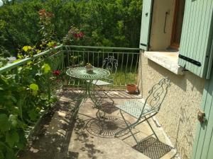 a patio with a table and chairs on a balcony at Daphrose chambre in Lachau