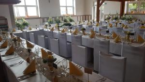 una habitación llena de mesas y sillas con mesas blancas y sillas en Hotel U Jelena en Havířov