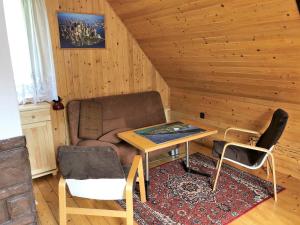 a living room with a couch and a table and chairs at domek w centrum w Zawoi in Zawoja