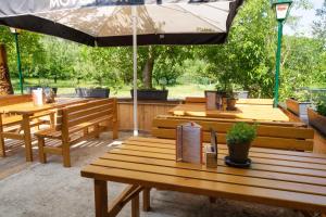 a group of wooden benches with an umbrella at Aprico in Traismauer