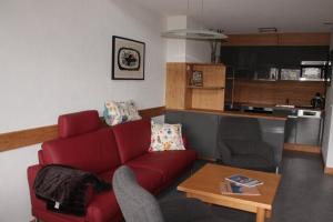 un soggiorno con divano rosso e tavolo di Disentiserhof Garvera - Maisonette Wohnung für max. 6 Personen a Disentis