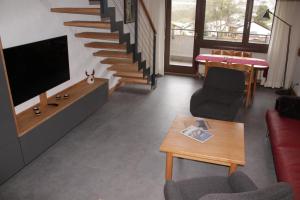 un soggiorno con divano, TV e scale di Disentiserhof Garvera - Maisonette Wohnung für max. 6 Personen a Disentis