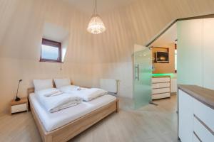 Schlafzimmer mit einem Bett mit weißer Bettwäsche und einem Spiegel in der Unterkunft Apartamenty Sun & Snow Willa Hania in Krynica Morska