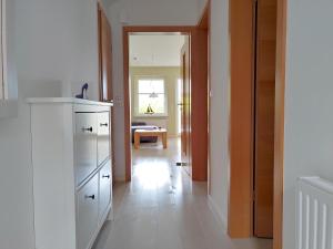 a kitchen with a white refrigerator and a hallway at Ferienwohnung *Haus Ose* in Wittdün
