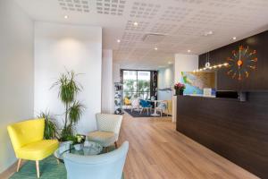 an office lobby with a glass table and yellow chairs at Best Western Hôtel Royan Océan in Royan