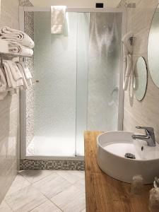 a white bathroom with a sink and a shower at Hotel Il Loggiato Dei Serviti in Como