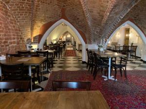 a restaurant with tables and chairs and a brick wall at Mayfair Hotel Tunneln in Malmö