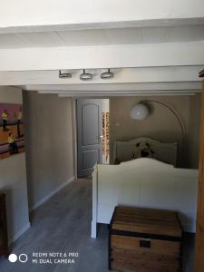een slaapkamer met een bed en een deur in een kamer bij lesfilatures in Saint-Vincent-de-Reins