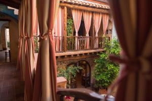 a room with a balcony and a large window at Hotel Anticos Palathos in Orosei