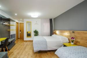 Habitación de hotel con cama y escritorio en Hostal-Restaurante LUGANO, en Verín